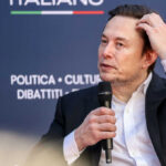 Musk’s Legal Defeat Sparks AI Ethics Storm Man in suit holding microphone at event indoors