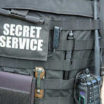 Close-up of a tactical vest worn by a security officer with 'SECRET SERVICE' label