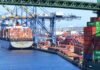 Pandemic Cartel UNMASKED – DOJ Exposes Chinese Scheme A cargo ship loaded with colorful containers docked at a busy shipping port