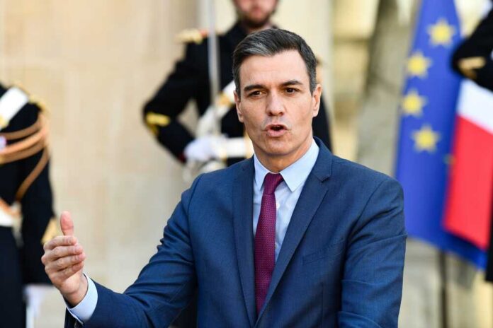 Pedro,Sánchez,Pérez-castejón,,Prime,Minister,Of,Spain,At,The,Elysee A government official delivering a speech outdoors with flags in the background