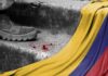 A military boot on concrete steps with blood stains and a Colombian flag draped nearby