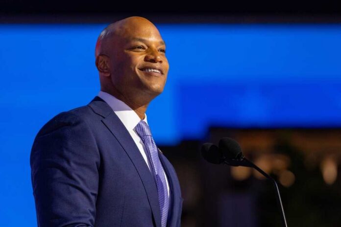 A confident speaker in a suit smiling while addressing an audience