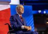 Illegal Degree Mill Busted by Texas Officials A man in a blue suit sitting in a wheelchair on a conference stage