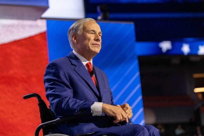 Milwaukee,,Wisconsin,-,July,17,,2024:,Texas,Governor,Greg,Abbott A man in a blue suit sitting in a wheelchair on a conference stage