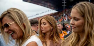 Three women at a race event, with one laughing and another looking thoughtful