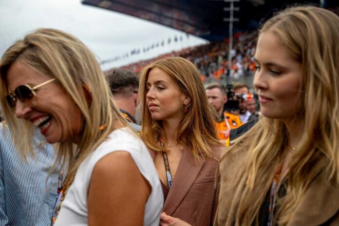 Three women at a race event, with one laughing and another looking thoughtful