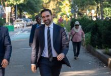 A man in a suit walking happily in a city park