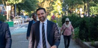 A man in a suit walking happily in a city park