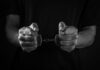 Hands holding handcuffs in a black and white image