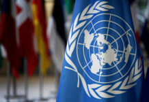 United Nations flag with other flags in background
