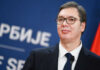 Rotten System—Students Demand Blood Man in suit with glasses standing at podium
