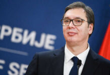 Man in suit with glasses standing at podium