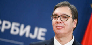 Man in suit with glasses standing at podium