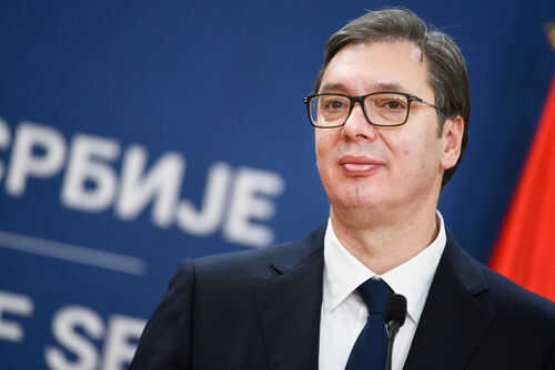 aleksandar-vui1676560987 Man in suit with glasses standing at podium