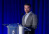 A man speaking at a podium in a suit