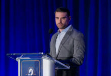 A man speaking at a podium in a suit