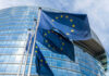 EU Hardens Ukraine Support Strategy in Cyprus Talks European Union flags outside modern glass building