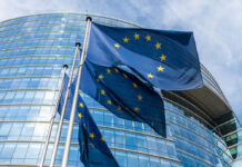 EU Hardens Ukraine Support Strategy in Cyprus Talks European Union flags outside modern glass building