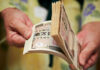 Global Money Rewired After Tokyo Move Hands counting a thick stack of Japanese yen banknotes