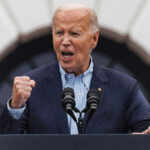Legal Minefield: DOJ Weighs Biden Pardons older man speaking passionately at a podium with two microphones
