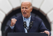 older man speaking passionately at a podium with two microphones