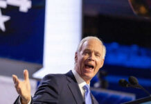 Man speaking passionately at a podium on stage