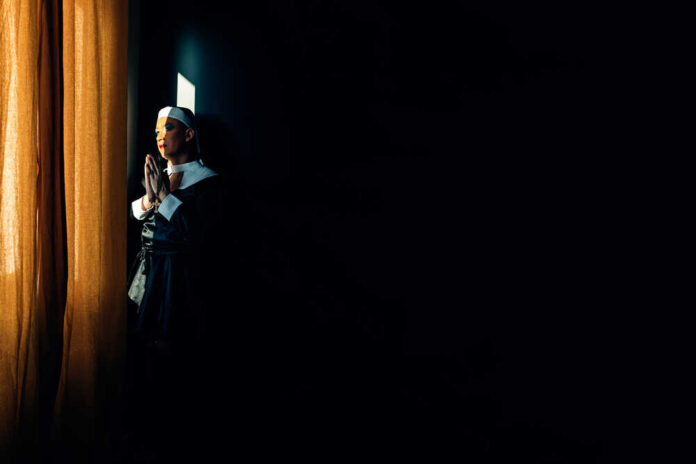 Devoted,Nun,Prays,In,The,Light,Of,A,Convent,Window. Police car with pride flag at a city parade