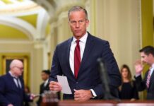 Capitol Standoff Freezes America’s Eyes Abroad A government official holding a document in a formal setting