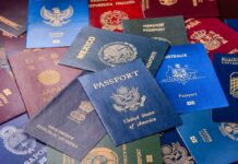 Backup Citizenship Boom — Washington Should Worry Hands using a calculator with travel documents and notes