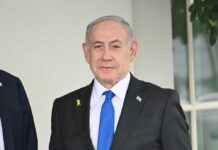 Netanyahu Defies Trump, Risk Soars A view of destroyed buildings with smoke rising in the background