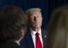 Trump Makes Banks Immigration Watchdogs A serious-looking man in a suit with a red tie, surrounded by blurred figures
