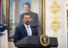Deportation Clock Starts — Courts Shut Out Man in suit speaking at a podium in an ornate room