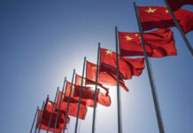 Beijing’s Grip Creeps North — CPP Playbook Exposed Multiple Chinese flags waving against a clear blue sky