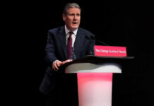 UK PM Starmer Out—Markets Eye Fiscal Chaos A man in a suit speaking at a podium.