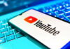 YouTube Star Turns Children’s Brand Into Protest Stage YouTube app on smartphone over illuminated laptop keyboard