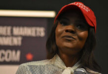 Evidence Avalanche Undercuts Candace Claims Woman in a red baseball cap holding a microphone