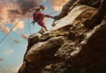 Air-Raid Sirens, New Climbing Culture Person rock climbing with ropes against a cloudy sky