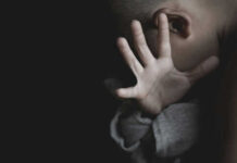 World Cup Sting: Children Pulled From Predators Child covering face with hand in dim light