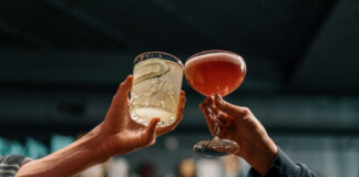 Two hands clinking cocktails