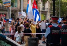 State Dept Flags Havana-Backed Protest Machine Crowd of protesters holding flags and signs behind police tape