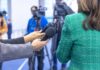 Press Battle Erupts: China Warns Retaliation Hands holding microphones in front of a person at a press conference