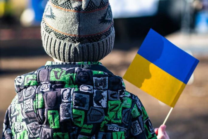 A,Child,Wearing,A,Colorful,Winter,Jacket,And,Knitted,Hat War crimes investigator in helmet at a damaged site