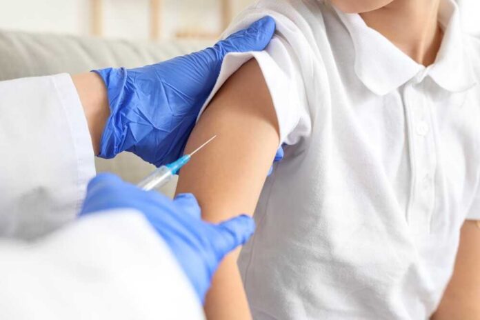 Ill,Little,Boy,With,Doctor,Vaccinating,At,Home,,Closeup A healthcare professional administering a vaccine to a child's arm
