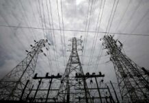 Grid Emergency: Diesel Generators Roar Back High-voltage transmission towers and power lines against a cloudy sky