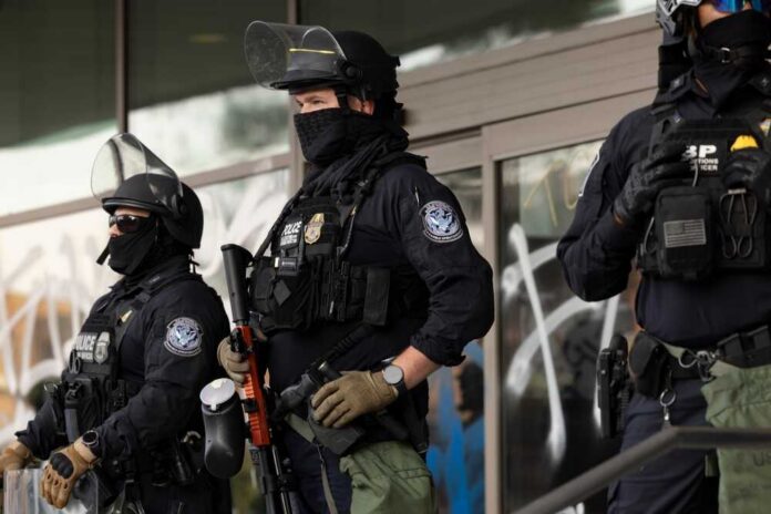Los,Angeles,,California,,Usa,-,June,10,,2025:,U.s.,Customs Riot police in tactical gear stand guard outside a building