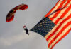 Skydiver descending with a large American flag parachute