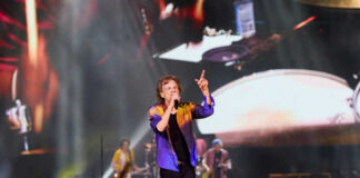 Lead singer performing on stage at a large concert