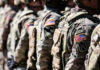 Alleged Assaults Vanish From Dahmer File Soldiers in camouflage with American flag patches standing