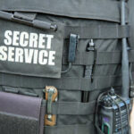 Stunning Intel Snub Exposed — Trump Left Open Tactical vest with equipment and a visible service patch