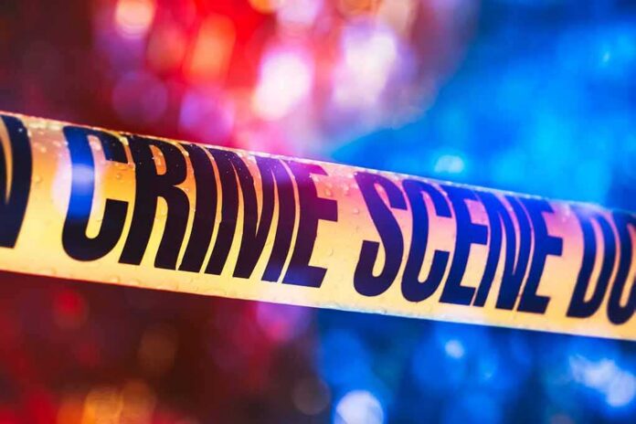 Crime scene tape with blurred emergency lights in background